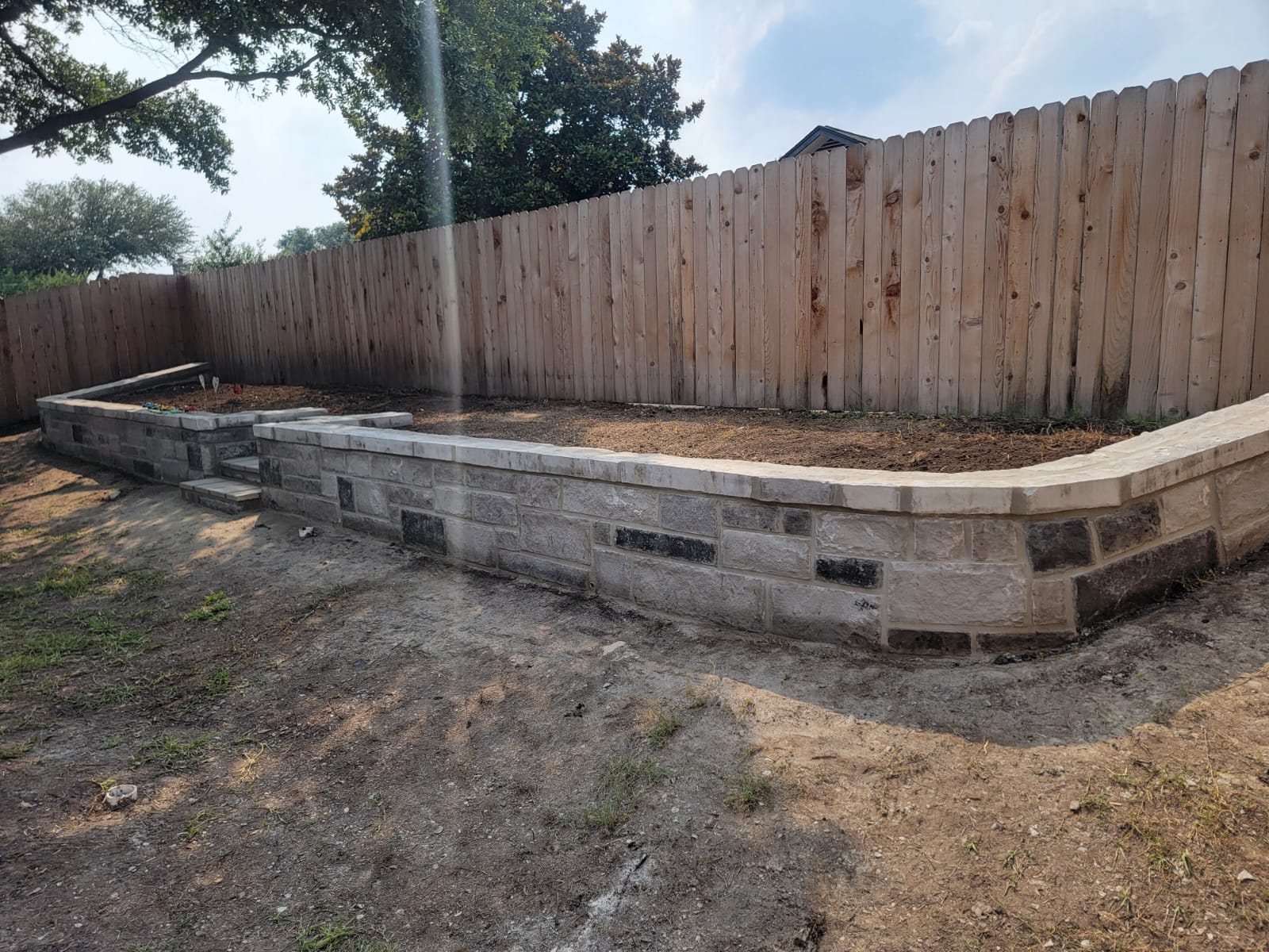Curved retaining wall with cap and planting bed