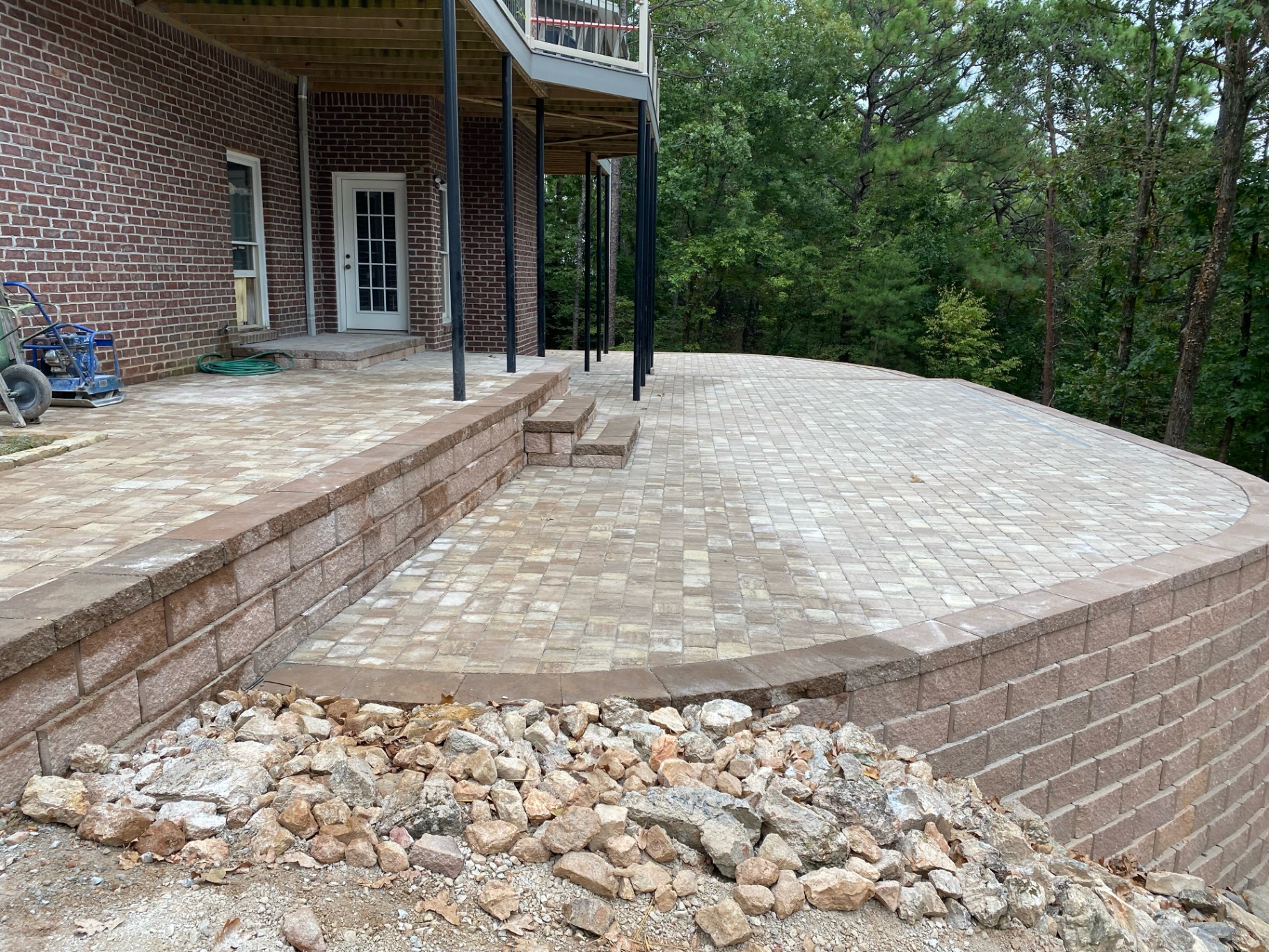 Paver patio and retaining wall project behind a brick home